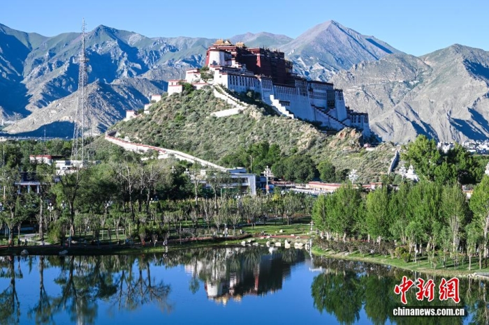 8月5日，随着西藏自治区成立60周年大庆临近，拉萨街头处处洋溢着喜庆氛围。市区主干道的路灯杆上，崭新的国旗与彩旗有序悬挂，鲜艳夺目。人行天桥完成升级改造，装饰板上国旗、石榴籽、牡丹花、浪潮、山川、连心结、雪山与哈达等元素相互交融，别具特色。工作人员正紧锣密鼓地布置花坛，五彩花卉将为城市增添斑斓色彩。此外，各大广场、公园也在装点，准备迎接八方来客。拉萨正以最美姿态，迎接这一重要时刻。图为从团结公园遥望布达拉宫。<a target='_blank' href='/'>中新社</a>记者 贡嘎来松 摄